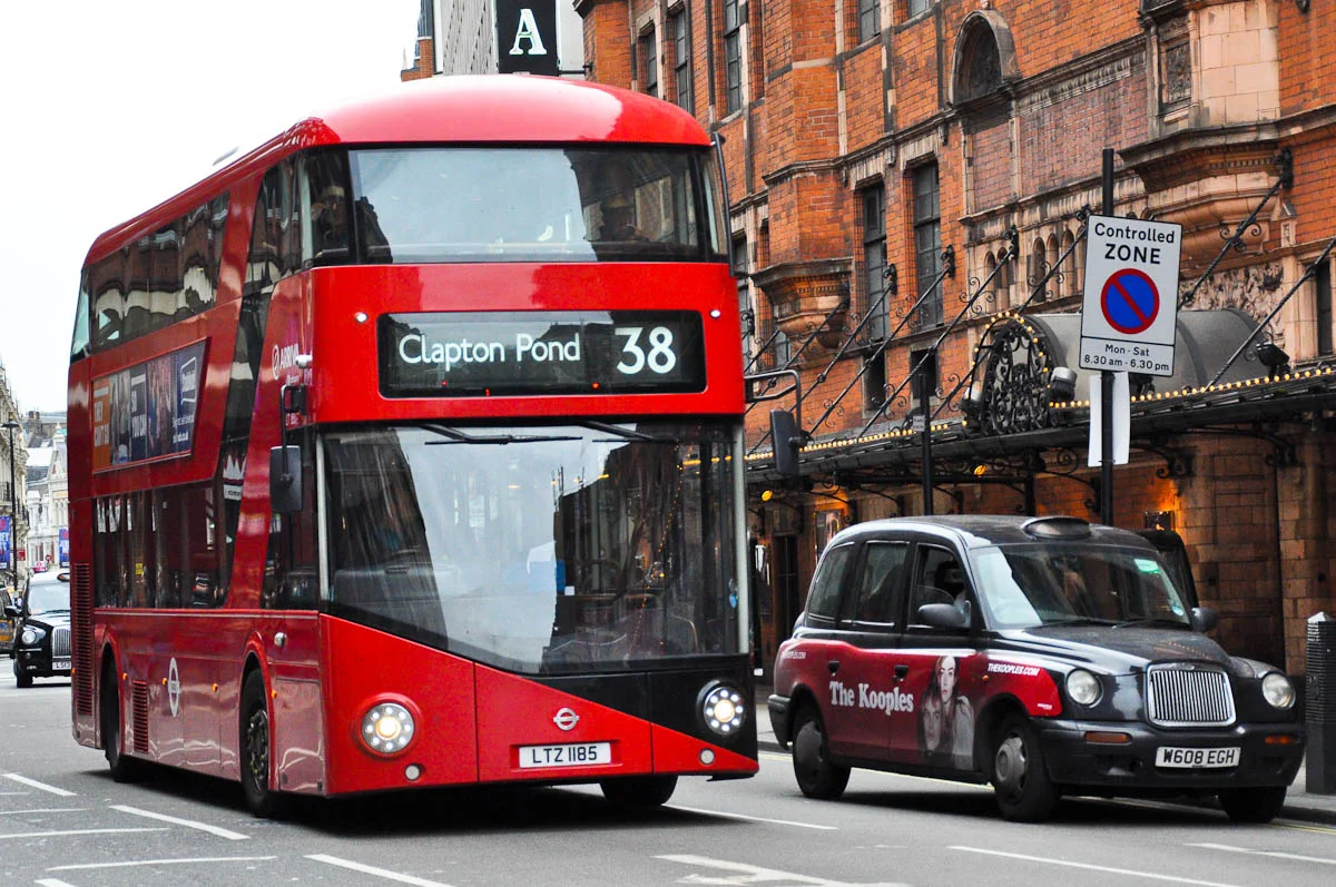 A red double-decker bus and a black cab on a London street, representing accessible public transport for accessible travel in London.